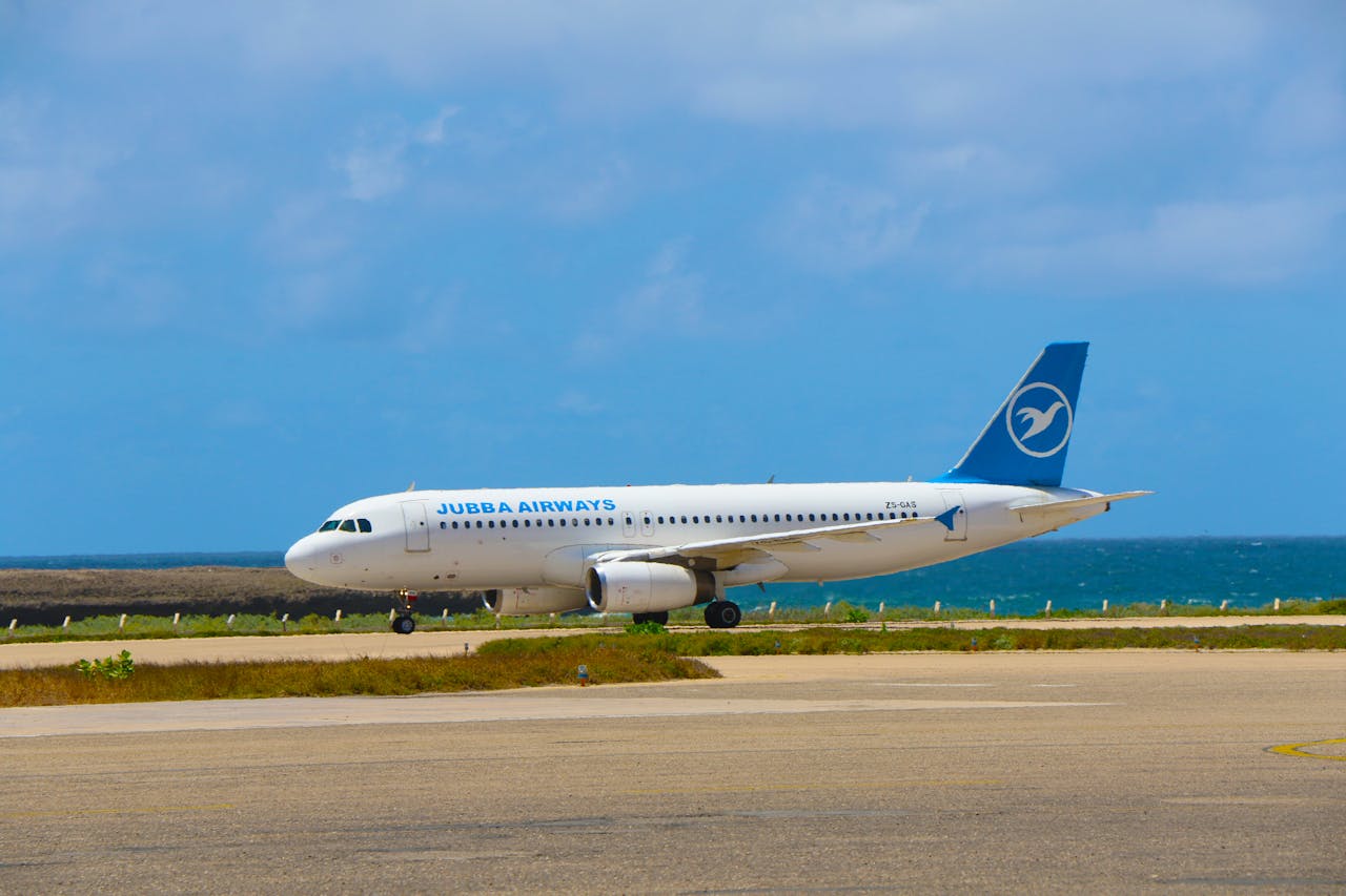 Jubba Airways plane parked at Mogadishu's seaside airport runway during daylight.